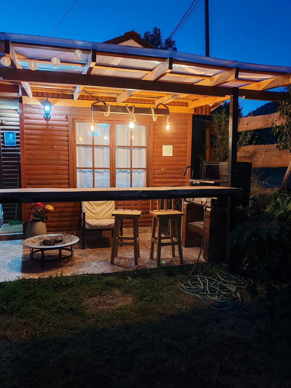 El quincho de noche, con luces cálidas y mesa